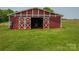 Exterior view of red barn with large doors open in a grass field at 5958 Hoover Elmore Rd, Lincolnton, NC 28092