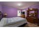 The primary bedroom has a patterned quilt, a dresser, and light purple walls at 5958 Hoover Elmore Rd, Lincolnton, NC 28092