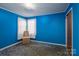 This bedroom has blue walls and carpet, with a window and a chair at 5958 Hoover Elmore Rd, Lincolnton, NC 28092