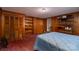 Bedroom with wood paneling and built in storage, featuring a blue quilt on the bed at 5958 Hoover Elmore Rd, Lincolnton, NC 28092