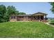 Charming brick home features a covered porch and lush front lawn, creating an inviting exterior at 5958 Hoover Elmore Rd, Lincolnton, NC 28092