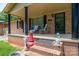 Welcoming front porch with comfortable seating, decorative columns, and brick accents offers a cozy outdoor space at 5958 Hoover Elmore Rd, Lincolnton, NC 28092