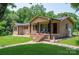 Charming brick home with a covered front porch, manicured lawn, and landscaped garden beds at 5958 Hoover Elmore Rd, Lincolnton, NC 28092
