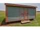 Small outbuilding/shed with a gray exterior and rustic wood trim at 5958 Hoover Elmore Rd, Lincolnton, NC 28092