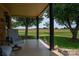 Covered porch with seating, dark support columns, and views of a tranquil landscape at 5958 Hoover Elmore Rd, Lincolnton, NC 28092