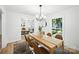 Bright dining room features modern chandelier, wood table, and views to the living room and outdoors at 6127 Eagle Peak Dr, Charlotte, NC 28214