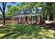 View of the front of a charming brick home with dormer windows and a well-manicured lawn at 6127 Eagle Peak Dr, Charlotte, NC 28214
