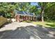 View of the brick home featuring a long driveway, dormer windows and a well-manicured lawn at 6127 Eagle Peak Dr, Charlotte, NC 28214