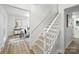 Open staircase with wood floors and white banister, leading to a bright living space at 6127 Eagle Peak Dr, Charlotte, NC 28214
