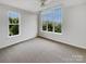 Bright, empty bedroom with carpet, large windows providing abundant natural light and neutral walls at 7130 Founders Club Ct, Charlotte, NC 28269