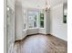 Bright dining room featuring hardwood floors, bay window, and elegant chandelier at 7130 Founders Club Ct, Charlotte, NC 28269
