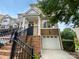 Charming townhome featuring a one-car garage and inviting entrance with brick accents and black railing at 7130 Founders Club Ct, Charlotte, NC 28269