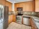 Kitchen featuring stainless steel appliances, tile backsplash, and natural wood cabinets at 7130 Founders Club Ct, Charlotte, NC 28269