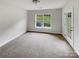 Clean, bright room with neutral carpet, large window with backyard view and glass panel door at 7130 Founders Club Ct, Charlotte, NC 28269