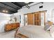 Bedroom featuring rustic wooden bed frame, decor, and sliding barn doors to bathroom at 720 Governor Morrison St # 219, Charlotte, NC 28211