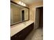 Well-lit bathroom with quartz countertop vanity, dark wood cabinets, and tile flooring at 9177 Bonnie Briar Cir, Charlotte, NC 28277