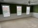 Bright bedroom with three windows, wainscotting and neutral carpet flooring at 9177 Bonnie Briar Cir, Charlotte, NC 28277