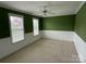 Bright bedroom with three windows, wainscotting and neutral carpet flooring at 9177 Bonnie Briar Cir, Charlotte, NC 28277