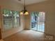 Sunny breakfast nook with a chandelier, window views and access to the outdoor patio at 9177 Bonnie Briar Cir, Charlotte, NC 28277