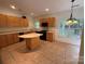 Bright kitchen featuring tile floors, wood cabinets, and a kitchen island for meal preparation at 9177 Bonnie Briar Cir, Charlotte, NC 28277