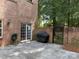 Private patio with brick walls, iron gate, grill, and sliding glass doors at 9177 Bonnie Briar Cir, Charlotte, NC 28277