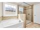 Bright bathroom featuring a separate tub and glass-enclosed shower with neutral-toned tile at 10004 Perth Moor Rd, Charlotte, NC 28278