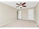 Bedroom with neutral paint and carpet, featuring a ceiling fan and two closets at 10004 Perth Moor Rd, Charlotte, NC 28278
