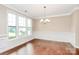Formal dining room with hardwood floors, large windows, and classic wainscoting at 10004 Perth Moor Rd, Charlotte, NC 28278
