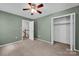 A charming bedroom with neutral carpet, light green walls, and a closet at 1006 Covewood Ct, Charlotte, NC 28270