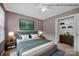Staged front bedroom featuring a large bed, closet and stylish furnishings at 1006 Covewood Ct, Charlotte, NC 28270