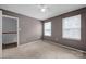 Bright bedroom with a carpeted floor, neutral walls, and two windows at 1006 Covewood Ct, Charlotte, NC 28270