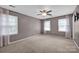 Carpeted bedroom featuring large windows and a ceiling fan at 1006 Covewood Ct, Charlotte, NC 28270
