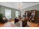 Digitally staged Gathering room offers hardwood floors, a modern desk area, and a cozy reading nook at 1006 Covewood Ct, Charlotte, NC 28270