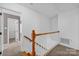 Upstairs hallway with carpet, wood banister and multiple entryways to bedrooms at 1006 Covewood Ct, Charlotte, NC 28270