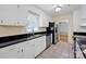 This kitchen offers white cabinets, black countertops, stainless steel appliances, and lots of natural light at 1006 Covewood Ct, Charlotte, NC 28270