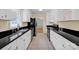 Well-lit kitchen with white cabinets, black countertops, stainless steel appliances, and tile flooring at 1006 Covewood Ct, Charlotte, NC 28270
