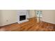 A bright living room featuring a brick fireplace, hardwood floors, and ample natural light from french doors at 1006 Covewood Ct, Charlotte, NC 28270