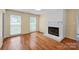 A spacious living room with hardwood floors and a brick fireplace is ready for your personal touch at 1006 Covewood Ct, Charlotte, NC 28270