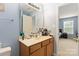 Bathroom features a single sink vanity with light brown cabinetry and an elongated mirror at 1108 Plaza Walk Dr, Charlotte, NC 28215