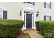 Elegant front door framed by sidelights and black sconces, surrounded by lush greenery at 1108 Plaza Walk Dr, Charlotte, NC 28215