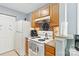 Cozy kitchen featuring wood cabinets and white appliances against gray walls at 1108 Plaza Walk Dr, Charlotte, NC 28215