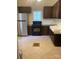 Traditional kitchen equipped with stainless steel appliances, dark wood cabinets, and tiled floors at 1126 Clement Ave, Charlotte, NC 28205