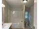 Bathroom showcasing a shower-tub combo and toilet adjacent to a bright window, complemented by vanity area with sink at 1201 Forest Ridge Rd, Bessemer City, NC 28016