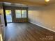 Bright living room featuring new floors, fresh paint, and natural light from the front door and windows at 1228 Archdale Dr # G, Charlotte, NC 28217