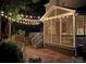 Inviting screened-in back porch with string lights for cozy evenings, steps down to a brick patio at 14203 Queens Carriage Pl, Charlotte, NC 28278