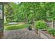 Private backyard featuring a small lawn, wooded area, and patio for outdoor enjoyment at 14203 Queens Carriage Pl, Charlotte, NC 28278
