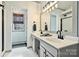 A well-lit bathroom with double sinks, updated fixtures, and stylish tile flooring that leads to the shower at 14203 Queens Carriage Pl, Charlotte, NC 28278