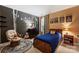Charming bedroom with black accent wall with tree decal, and a comfortable chair and warm, colorful decor at 14203 Queens Carriage Pl, Charlotte, NC 28278