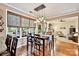 Dining area open to the living room with hardwood floors, pendant lights, and large windows with woven shades at 14203 Queens Carriage Pl, Charlotte, NC 28278