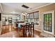 Dining area open to the kitchen with hardwood floors, pendant lights, and view of screened porch and backyard at 14203 Queens Carriage Pl, Charlotte, NC 28278